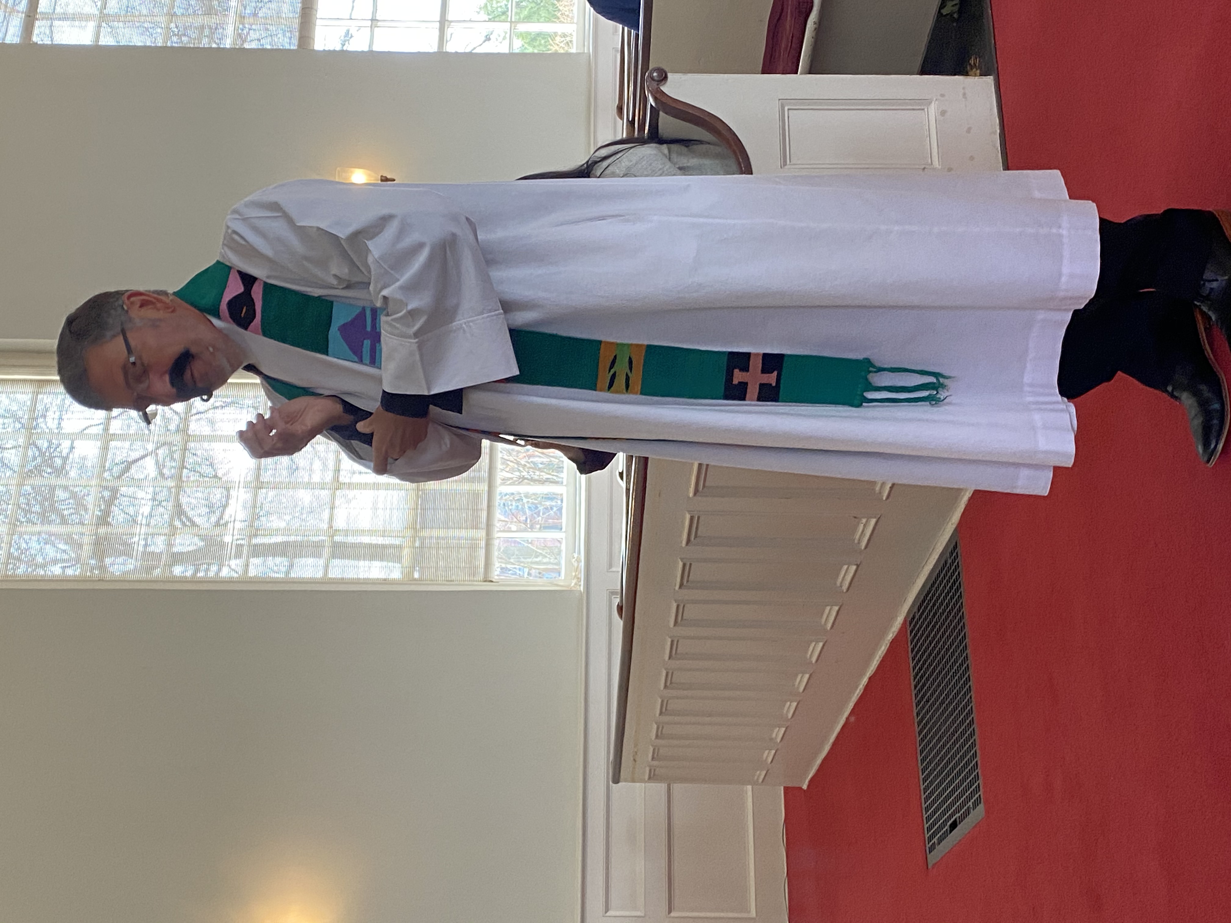 A man in religious robes speaking inside a church.